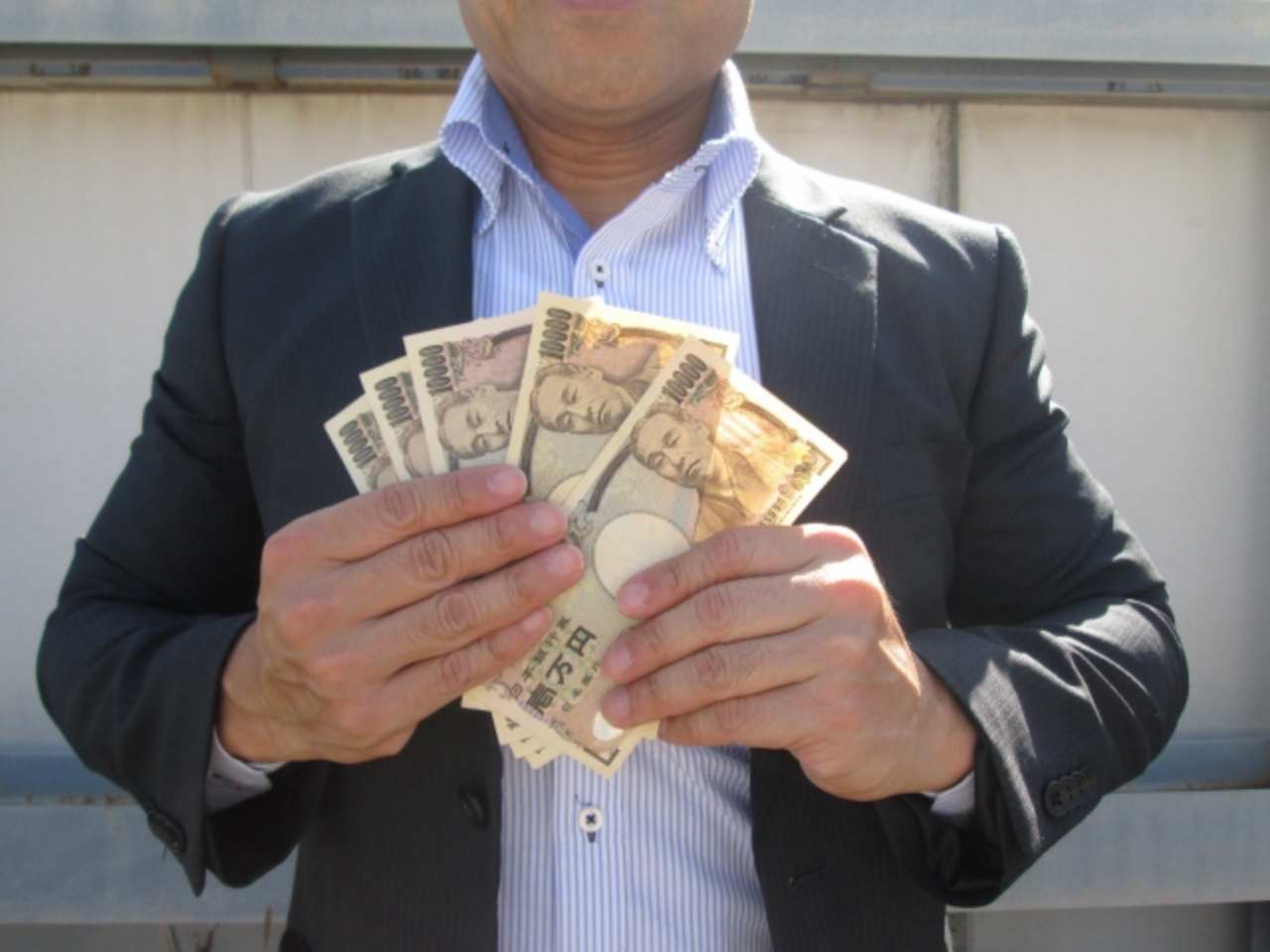 5万円を持つ男性