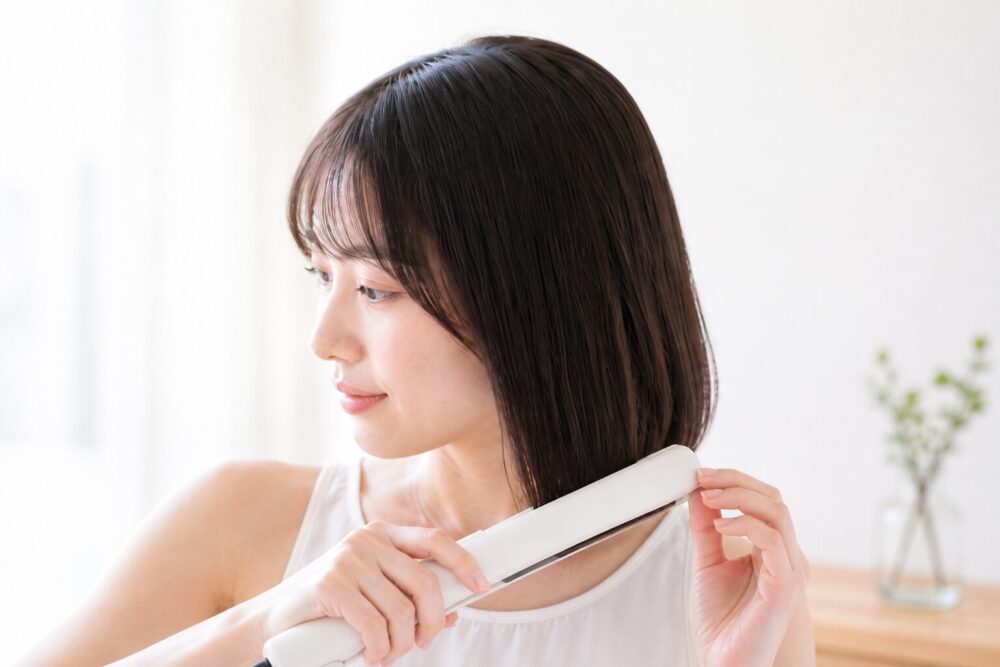 ストレートアイロンを使うボブの女性