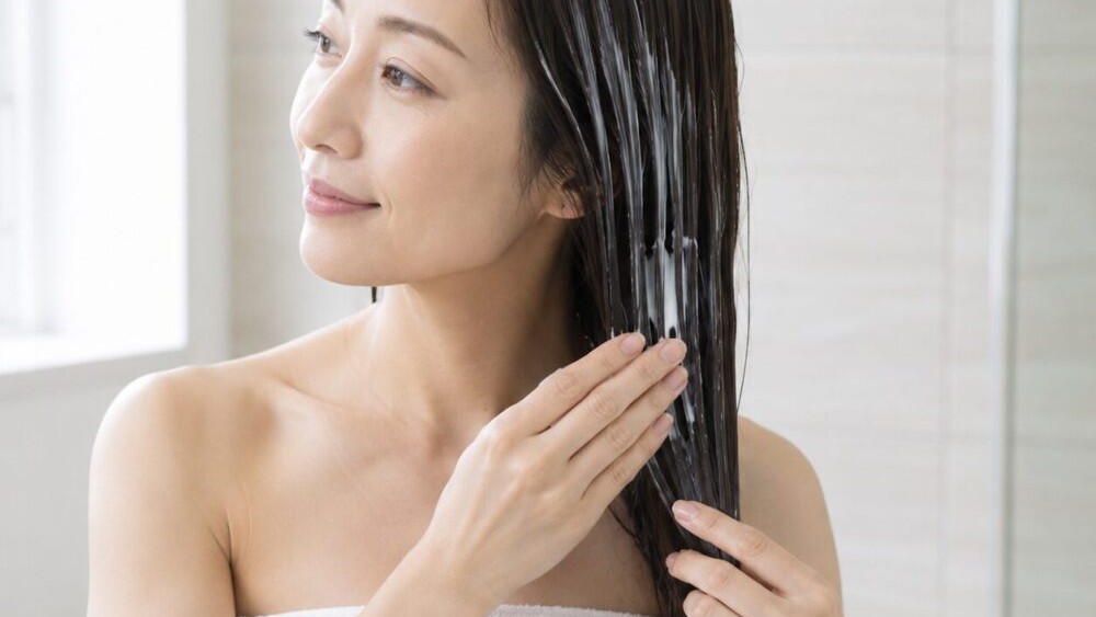 トリートメントを髪に塗布しているヘアケアシーン