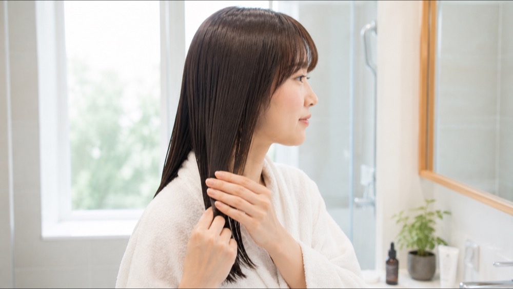 お風呂上がりにヘアケアをする女性