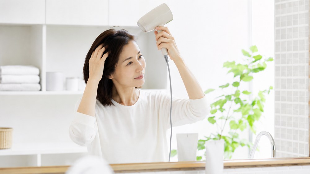 正しいドライヤーの使い方で髪を乾かす様子