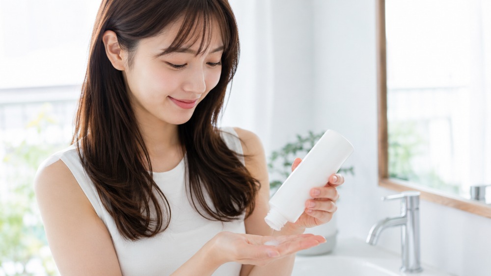 乳液タイプのトリートメントを手に取る女性のイメージ
