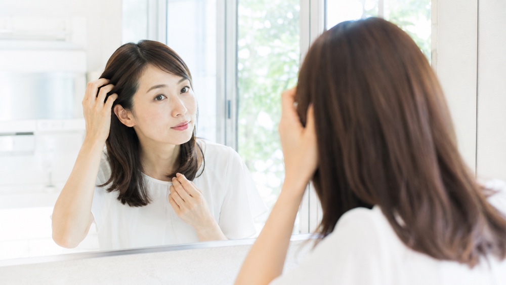 正しいヘアケアで髪を整える女性