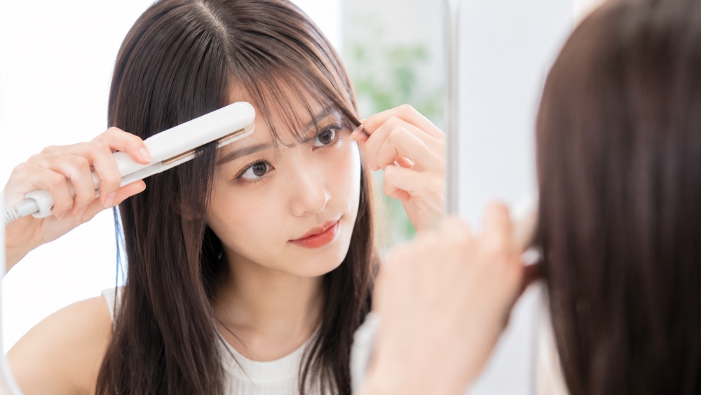 前髪をアイロンで整える女性