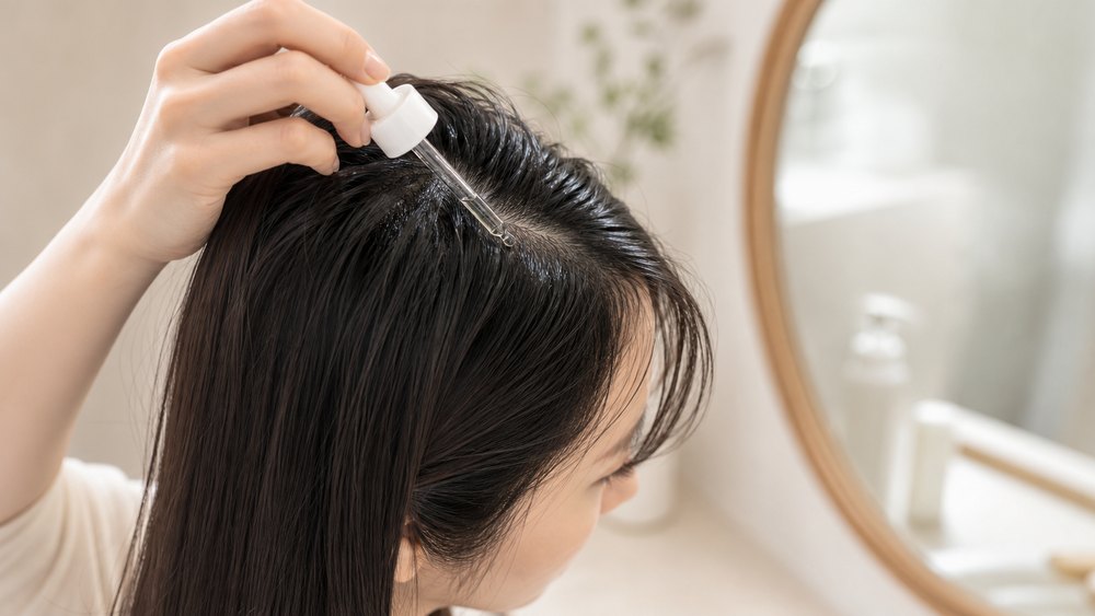 ヘアオイルを頭皮や根元近くにつけてベタつく様子