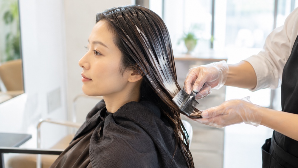 美容室で髪質改善トリートメントを受ける女性