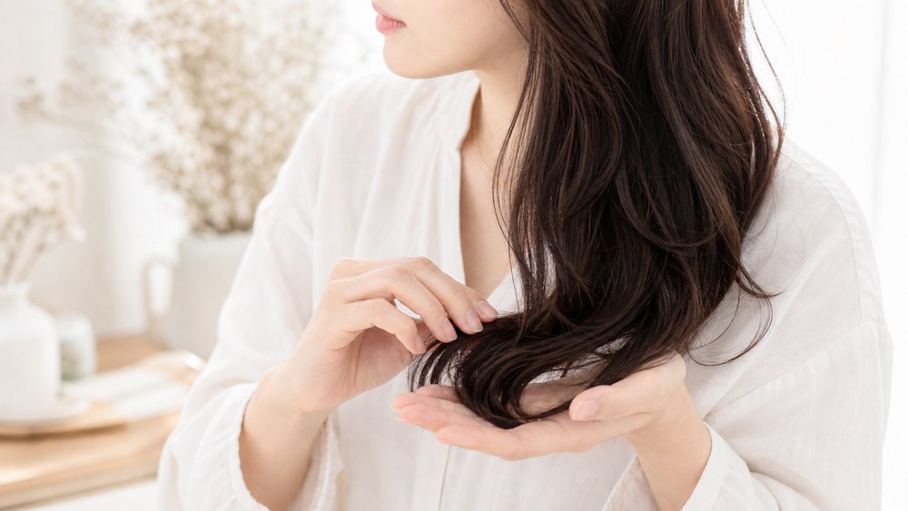 仕上げオイルでくせ毛の毛先と湿気をケアする様子