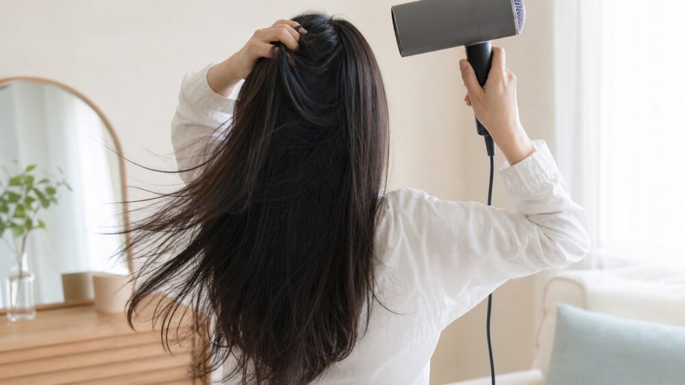 ドライヤーで髪を根元から丁寧に乾かす
