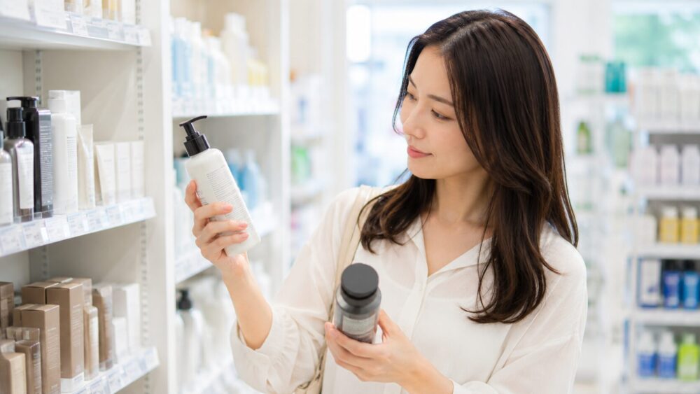 ドラッグストアでヘアケア商品を選ぶ日本人女性