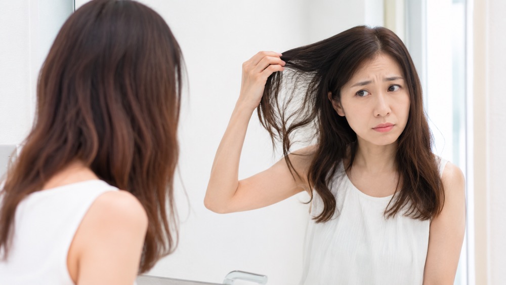 縮毛矯正で傷んだ毛先を気にする女性