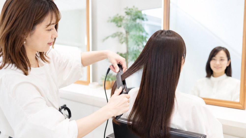 電卓と髪のケア用品を前に家計を考える女性