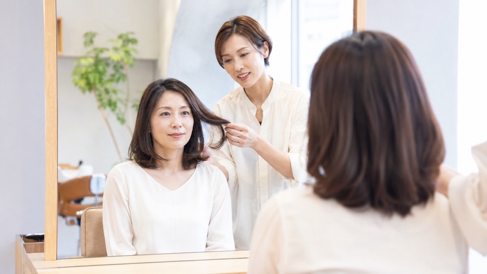 髪質改善後に広がった髪を気にする女性とツヤのある仕上がりの比較