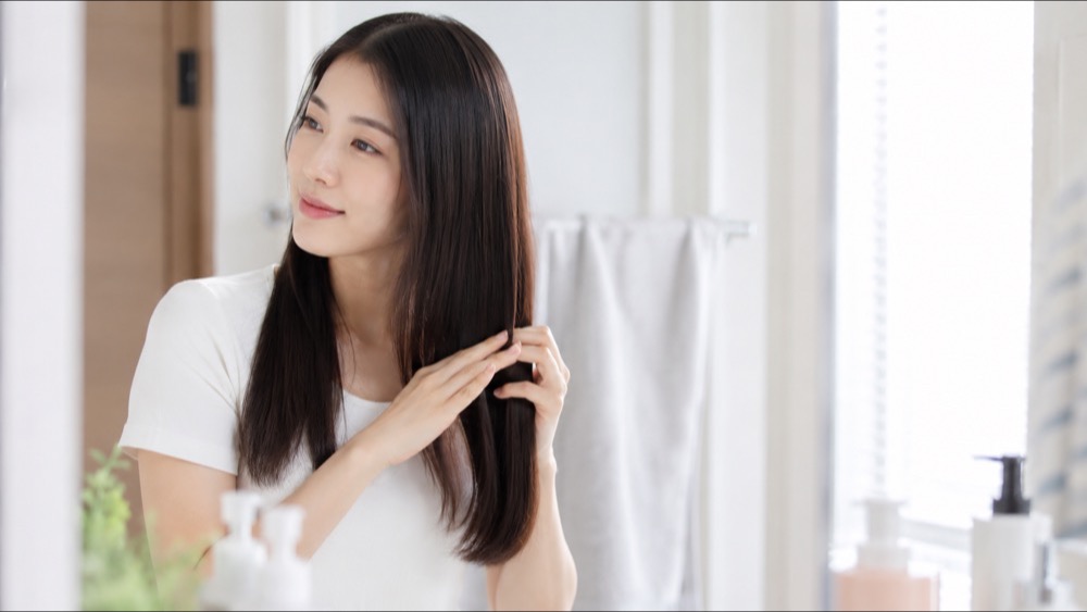 縮毛矯正後にホームケアをする女性