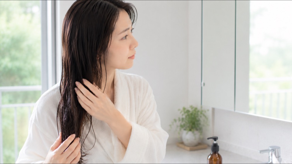 お風呂上がりにアウトバスケアをする女性
