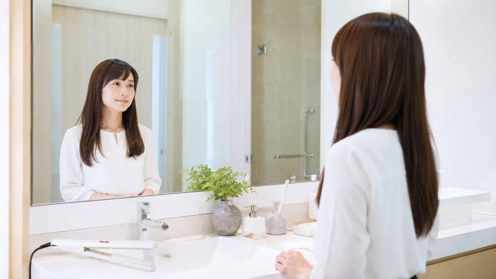 アイロンの立ち上がりを待つ女性