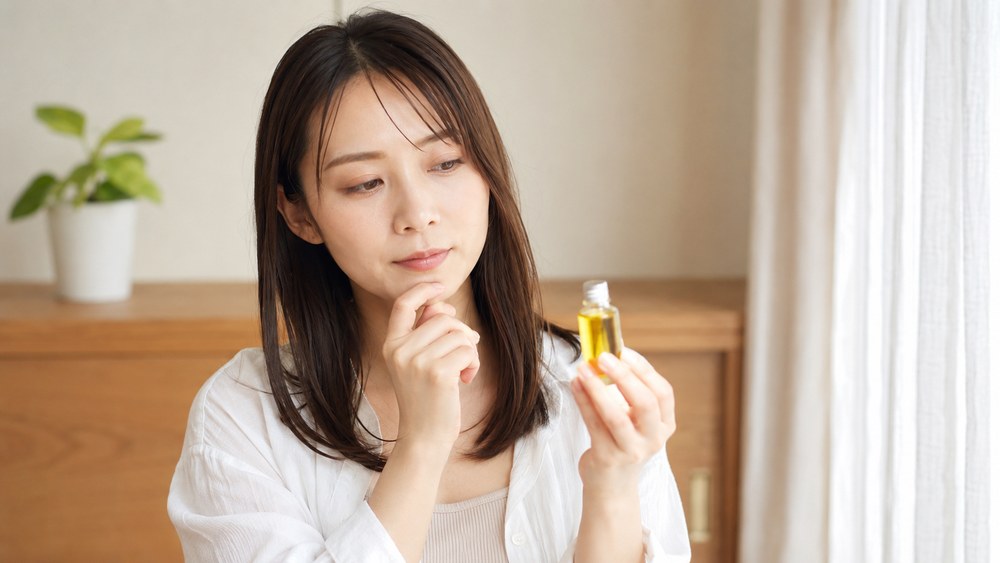 ヘアオイルを使うか考える女性