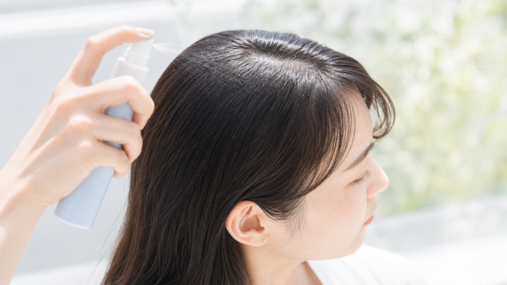 髪用UVスプレーを分け目にかける頭皮の日焼け対策