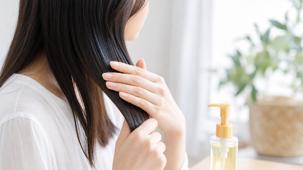 UVケア成分入りのヘアオイルで髪をコーティングする様子