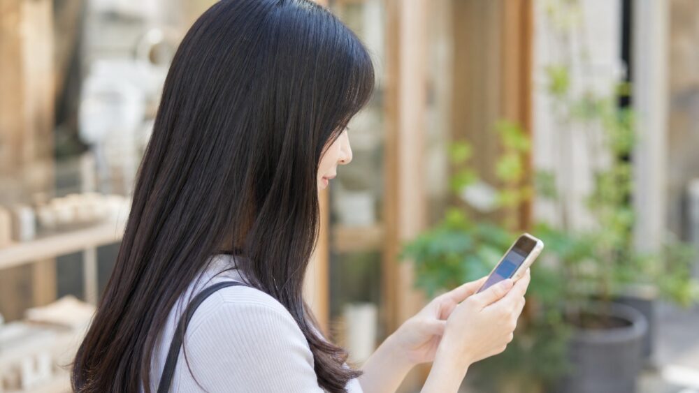 スマホでクーポンを見る若い女性