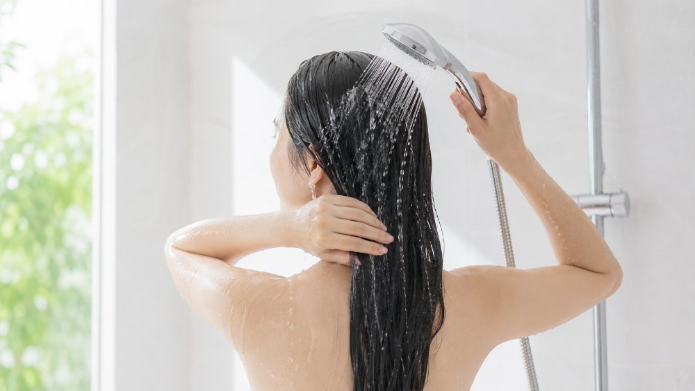 シャワーで髪をすすぐ女性の後ろ姿