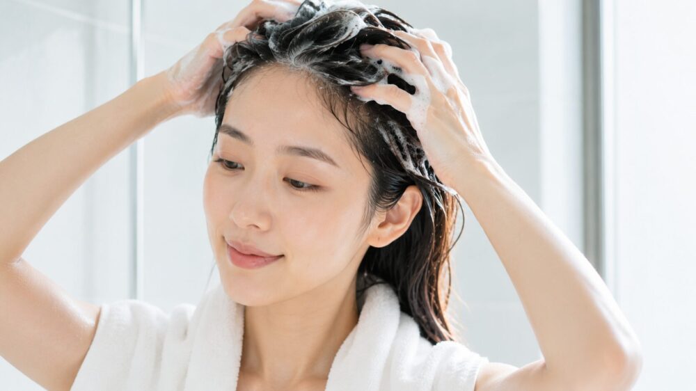 バスルームでシャンプーを泡立てる日本人女性