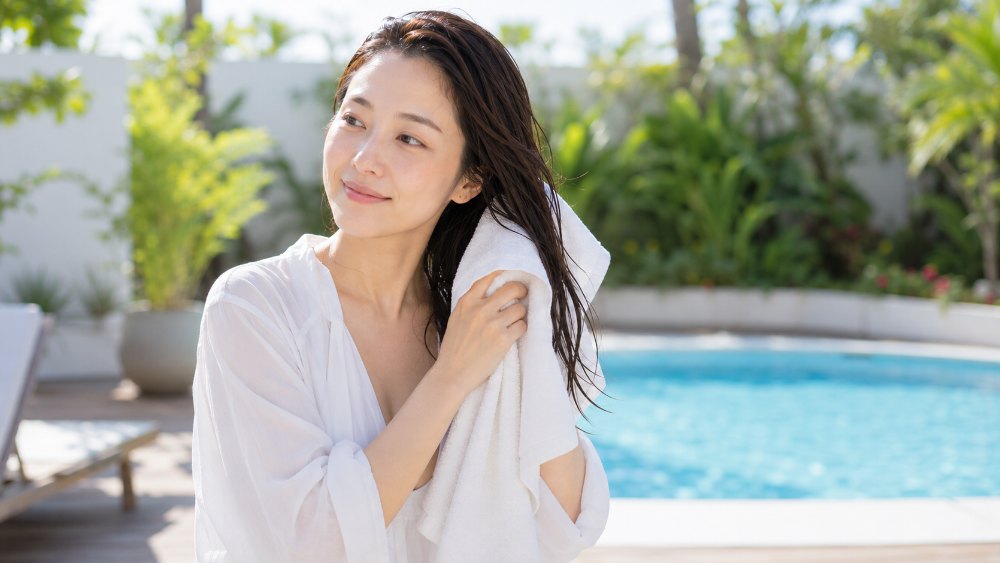 プールサイドでタオルドライする女性