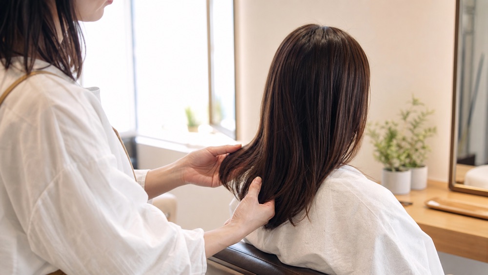 縮毛矯正のやり直し対象になる髪を確認する美容師