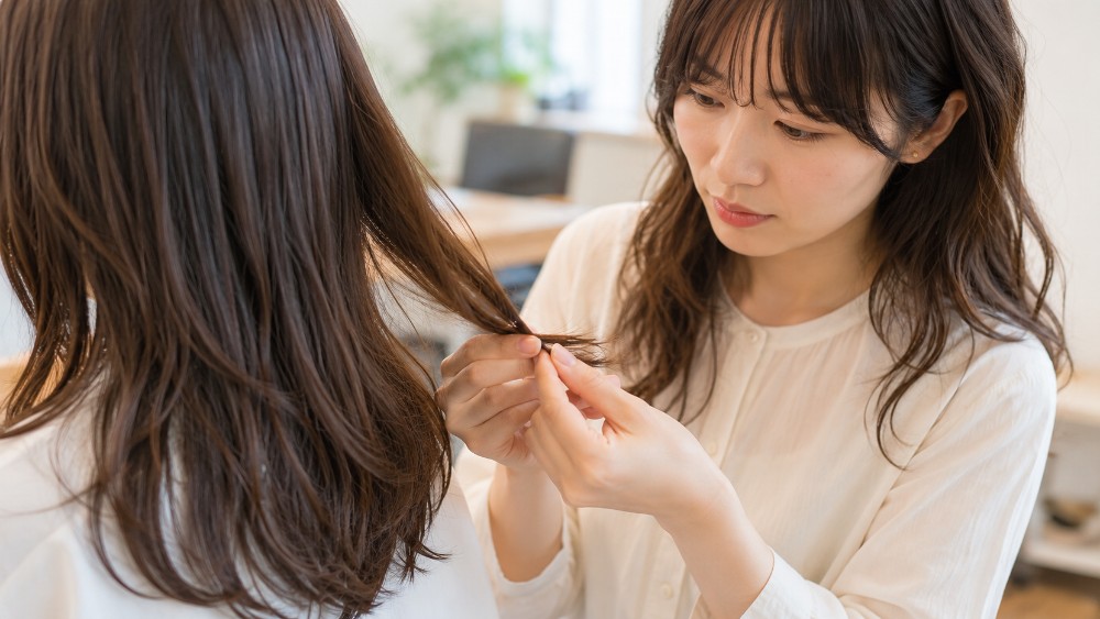 毛先のダメージを確認する美容師の手元