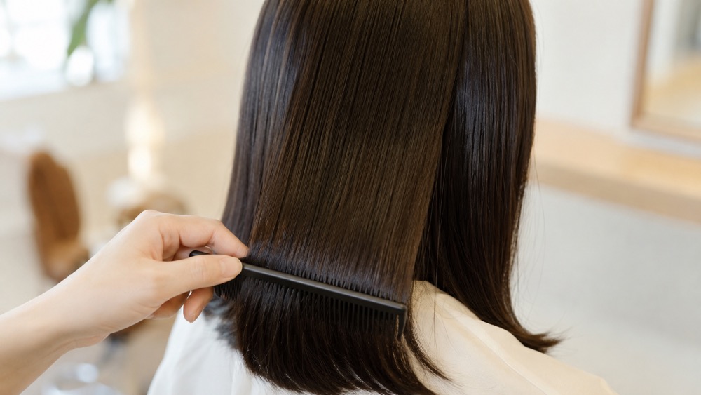 ツヤのあるストレートヘアにコームを通す様子