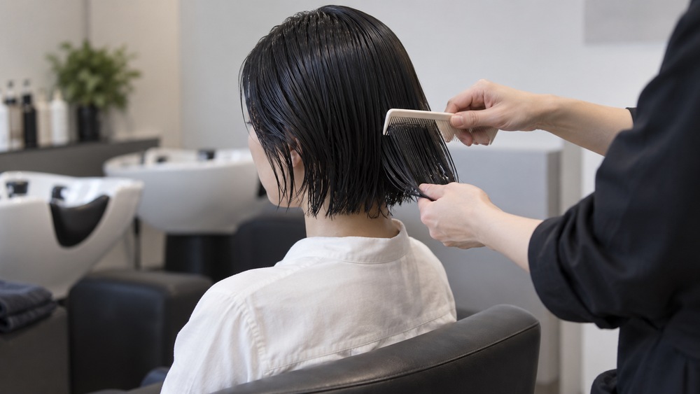 縮毛矯正後の落ち着いた短い髪をコームで整える様子
